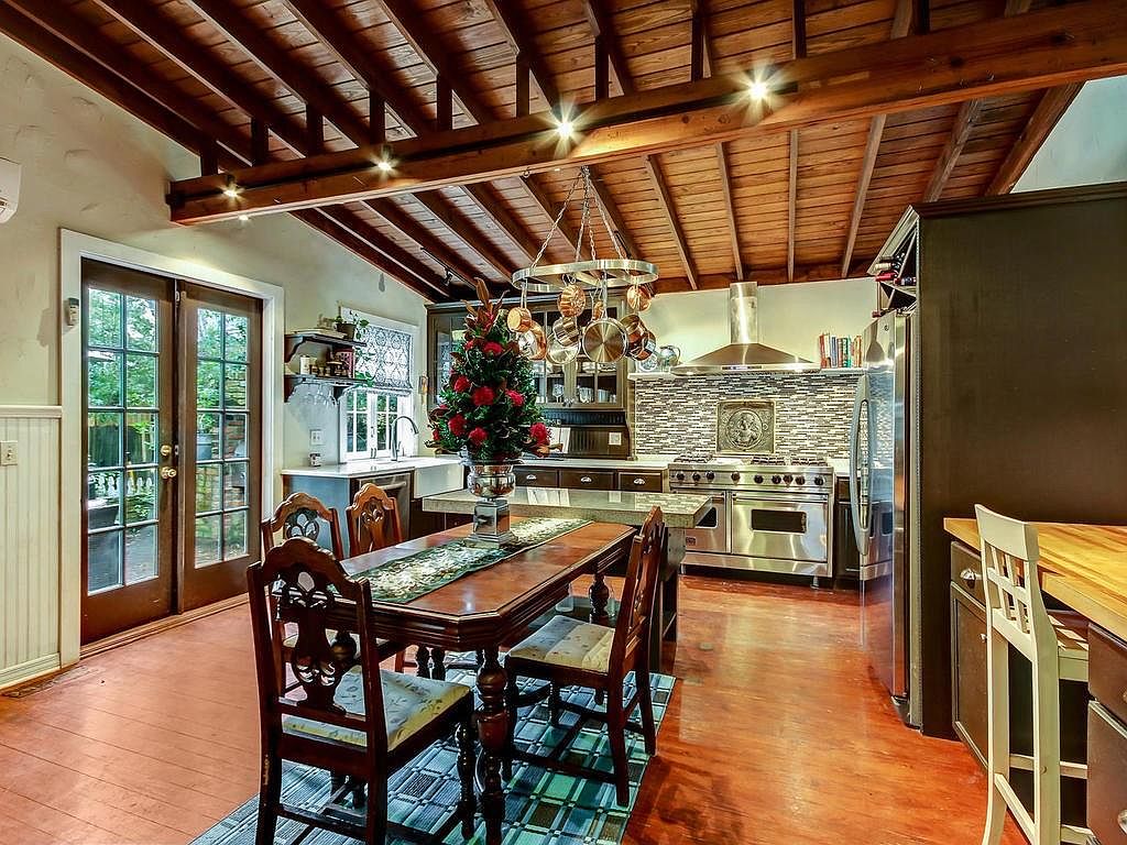 Gourmet kitchen with vaulted wood ceiling, stone island, and professional appliances