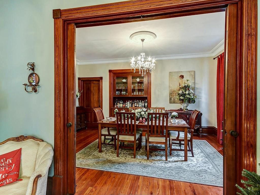 Formal dining room viewed through original pocket doors with mahogany trim